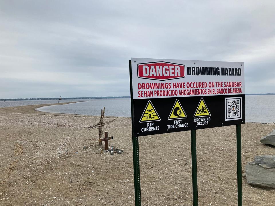 A sign at Conimicut Park in Warwick warns of dangerous currents after a 10-year-old girl and a man who tried to save her drowned there on Father's Day in 2021.