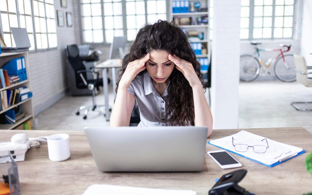 Woman looking frustrated at laptop