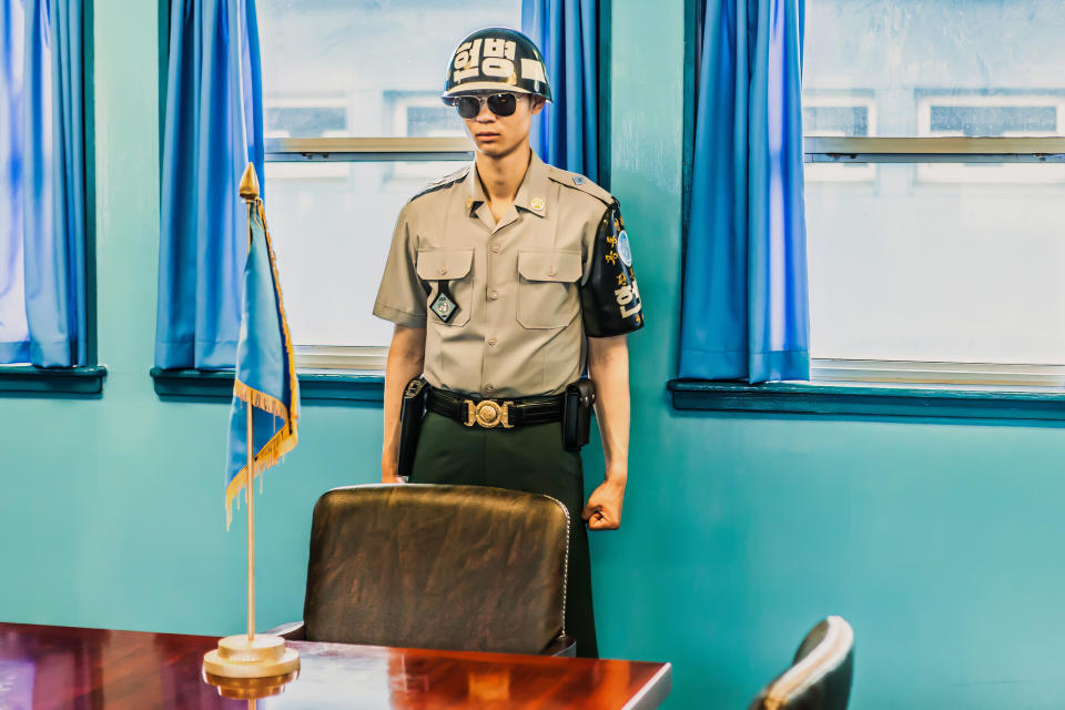 Both American and South Korean soldiers stands guard within one of the blue conference rooms. 