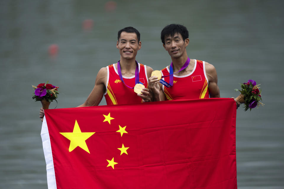 China's Fan Junjie, left, and Man Sun celebrate with their gold medals after winning the lightweight men's double sculls rowing at the 19th Asian Games in Hangzhou, China, Sunday, Sept. 24, 2023. (AP Photo/Louise Delmotte)