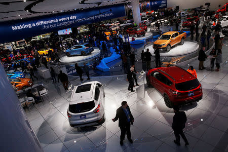 Visitors look at cars in the Ford booth at the North American International Auto Show in Detroit, Michigan, U.S. January 15, 2018. REUTERS/Jonathan Ernst