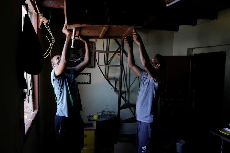 People carry furniture to be relocated prior to the arrival of Storm Elsa, in Havana