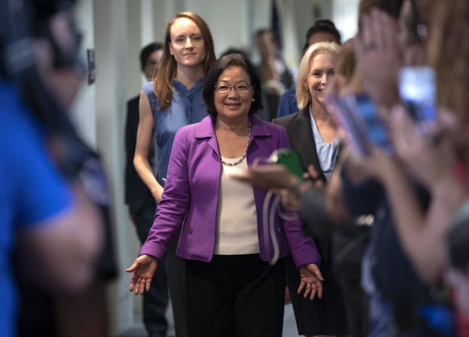 Sen. Mazie Hirono, D-Hawaii, flanked by Sarah Burgess, left, an alumnae of the Holton Arms School, and Sen. Kirsten Gillibrand, D-N.Y., right, is applauded by demonstrators as they arrive to speak to reporters in support of professor Christine Blasey Ford, who is accusing Supreme Court nominee Brett Kavanaugh of a decades-old sexual attack, during a news conference on Capitol Hill in Washington, Thursday, Sept. 20, 2018. Christine Blasey Ford was a student at the Holton Arms School, a Maryland all-girls school, in the early 1980s. (AP Photo/J. Scott Applewhite)