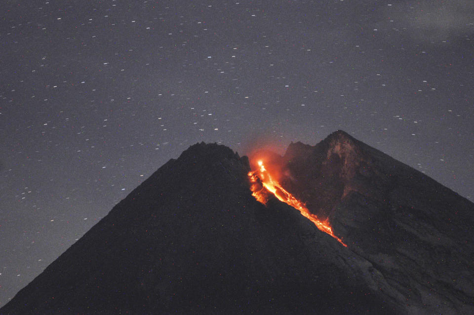 In this Tuesday, Jan, 29, 2019, photo. Mount Merapi spews volcanic material as it erupts as seen from Cangkringan, Yogyakarta, Indonesia. Indonesia's most volatile volcano unleashed a 1,400 meters (4,600 feet) dark red volcanic material 1,400 meters (1,500 yards) down the slopes. (AP Photo/Slamet Riyadi)