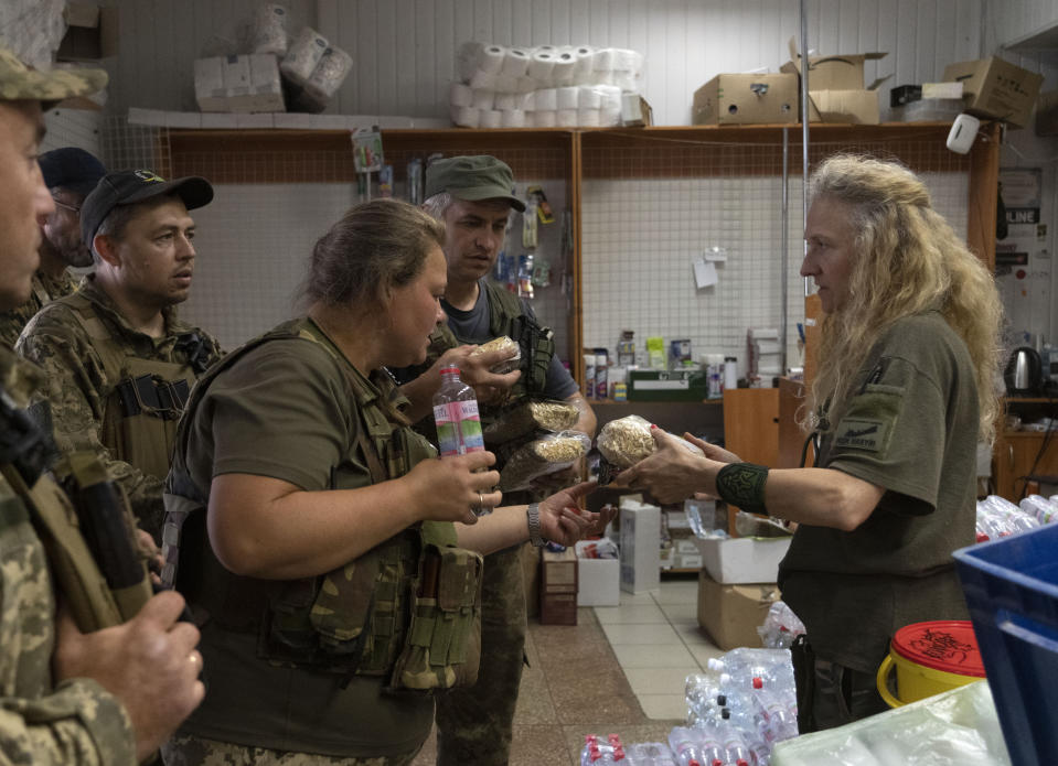 FILE - Volunteer Tetyana Khimion, 43, right, gives volunteer aid to servicemen in a volunteer centre in Slovyansk, Donetsk region, Ukraine, Thursday, June 30, 2022. (AP Photo/Efrem Lukatsky, File)