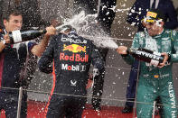First place, Red Bull driver Max Verstappen of the Netherlands, center, celebrates on the podium with second place, Aston Martin driver Fernando Alonso of Spain, right, during the Monaco Formula One Grand Prix, at the Monaco racetrack, in Monaco, Sunday, May 28, 2023. (AP Photo/Luca Bruno)