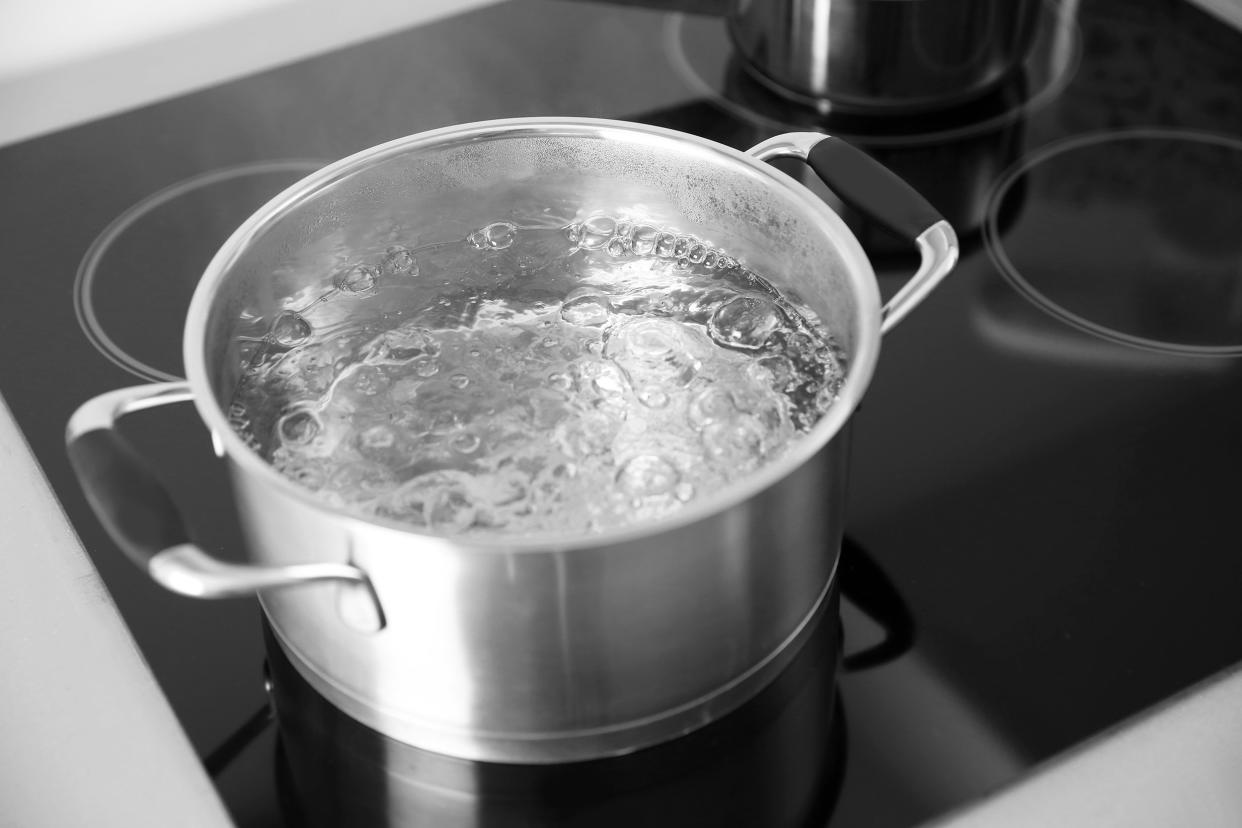 boiling water in pan on electric stove in the kitchen
