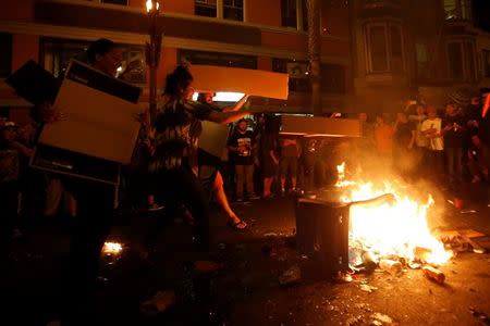 Revellers add fuel to a street bonfire in celebration in San Francisco, California October 29, 2014. REUTERS/Stephen Lam