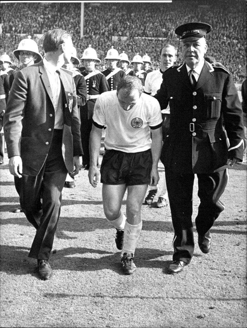 Ein sichtlich gezeichneter Uwe Seeler wird nach dem gegen Gastgeber England verlorenen WM-Endspiel 1966 vom Platz geleitet. (Bild: BROADVIEW /picurealliance)
