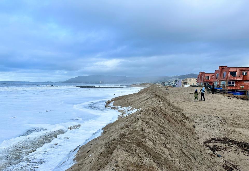 Waves wash up to the base of a sand berm in Ventura's Pierpont neighborhood on Saturday morning, Dec. 30, 2023. Firefighters built up the berm to protect homes after a rogue wave rushed through the area Thursday amid high surf.