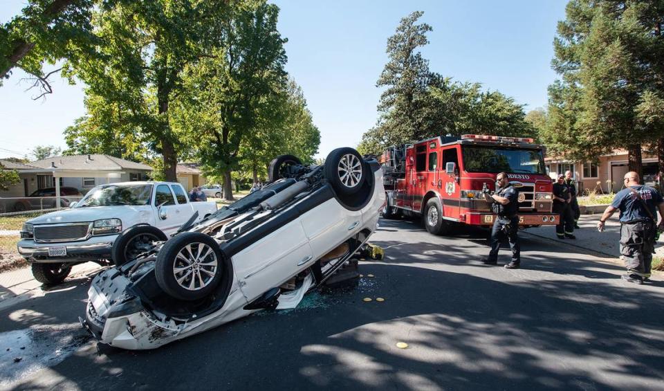 Bomberos del Departamento de Bomberos de Modesto revisan un vehículo involucrado en un accidente de volcadura en Bowen Avenue, en Modesto, California, el miércoles 5 de octubre de 2022.