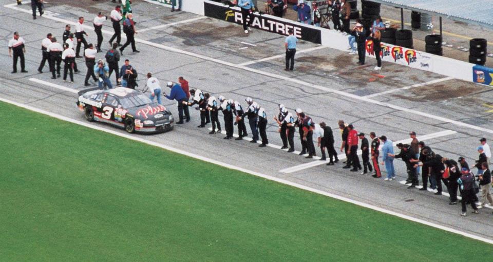 Crew members line up to slap hands with Dale Earnhardt