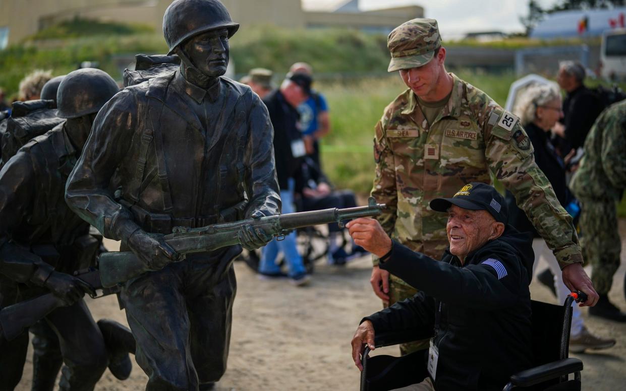 American World War II veteran Anthony Pagano, 97, touches a sculpture prior a ceremony at Utah Beach near Sainte-Marie-du-Mont, Normandy, France