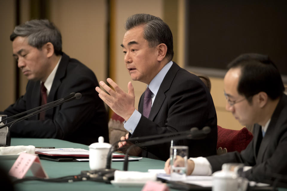 Chinese Foreign Minister Wang Yi, center, speaks during a press conference on the sidelines of the annual meeting of China's National People's Congress (NPC) in Beijing, Friday, March 8, 2019. China's foreign minister says Beijing will "take all necessary measures" to defend its companies following legal conflicts between tech giant Huawei and the United States. (AP Photo/Mark Schiefelbein)