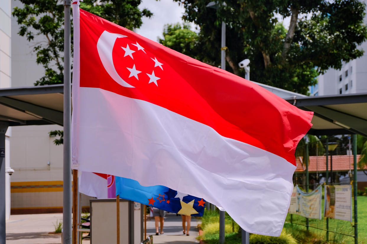 A closeup view of the Singapore flag in an HDB neighbourhood. 