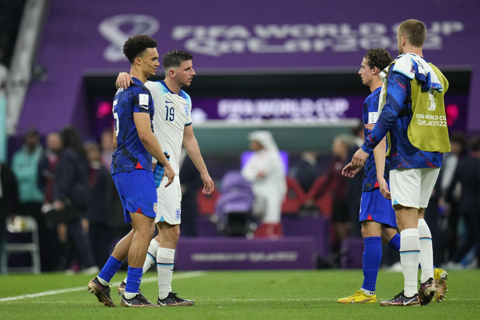 Antonee Robinson of the United States, left, and England's Mason Mount, second from left, walk on the pitch at the end of the World Cup group B soccer match between England and The United States, at the Al Bayt Stadium in Al Khor , Qatar, Friday, Nov. 25, 2022. (AP Photo/Julio Cortez)