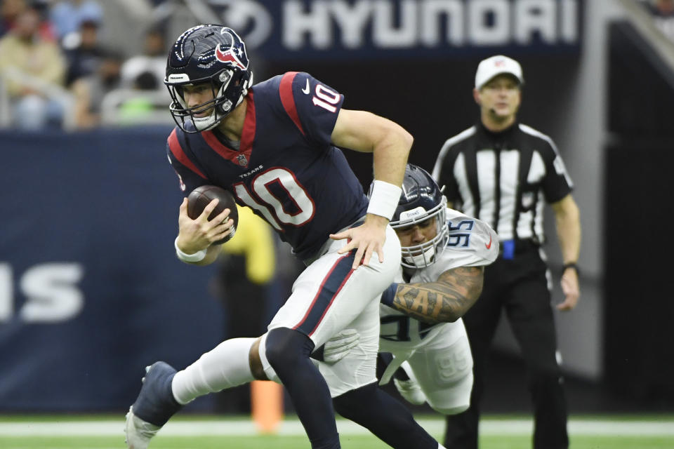 Houston Texans quarterback Davis Mills (10) is pressured by Tennessee Titans defensive tackle Anthony Rush (95) during the first half of an NFL football game, Sunday, Jan. 9, 2022, in Houston. (AP Photo/Justin Rex )