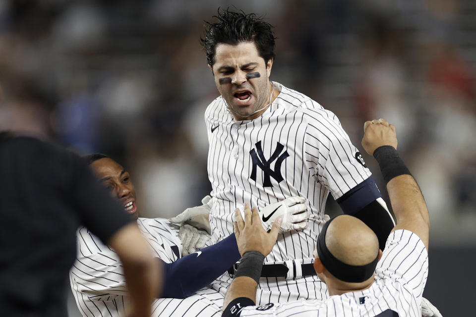 New York Yankees' Ryan LaMarre celebrates with teammates after driving in the winning run against the Philadelphia Phillies during the 10th inning of a baseball game Wednesday, July 21, 2021, in New York. The Yankees won 6-5. (AP Photo/Adam Hunger)