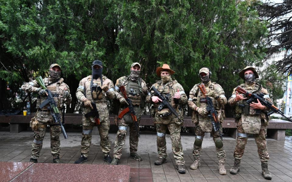 Fighters of Wagner private mercenary group pose for a picture as they get deployed near the headquarters of the Southern Military District in the city of Rostov-on-Don
