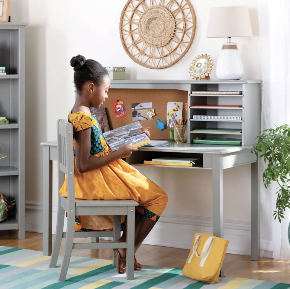 child sitting at gray desk