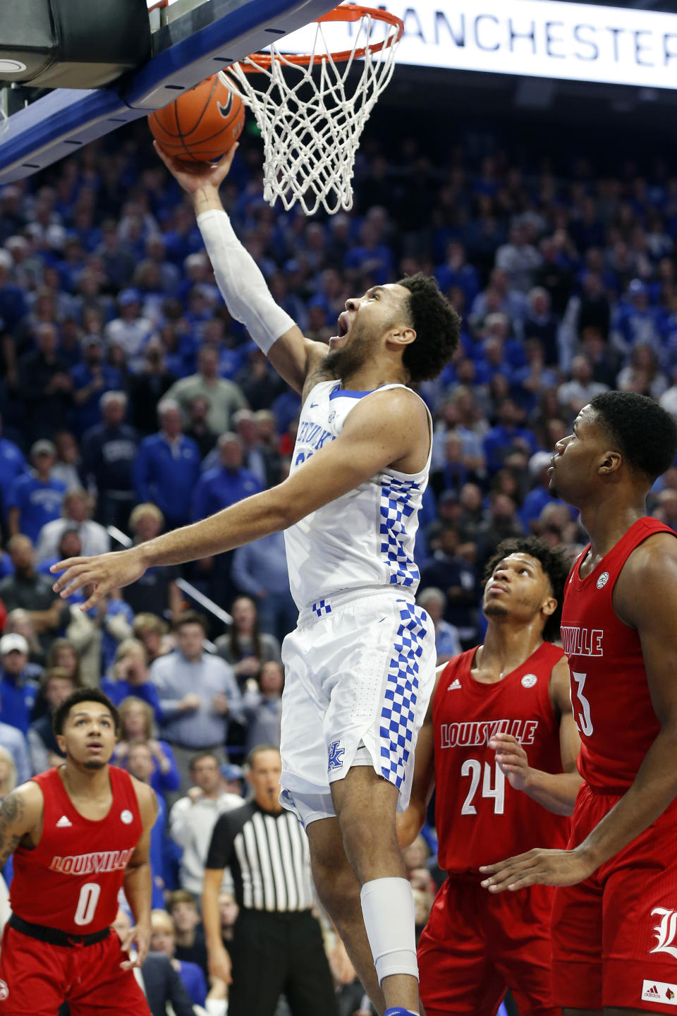 Kentucky's EJ Montgomery, middle, shoots between Louisville's Lamarr Kimble (0), Dwayne Sutton (24) and Steven Enoch (23) during the first half of an NCAA college basketball game in Lexington, Ky., Saturday, Dec. 28, 2019. (AP Photo/James Crisp)