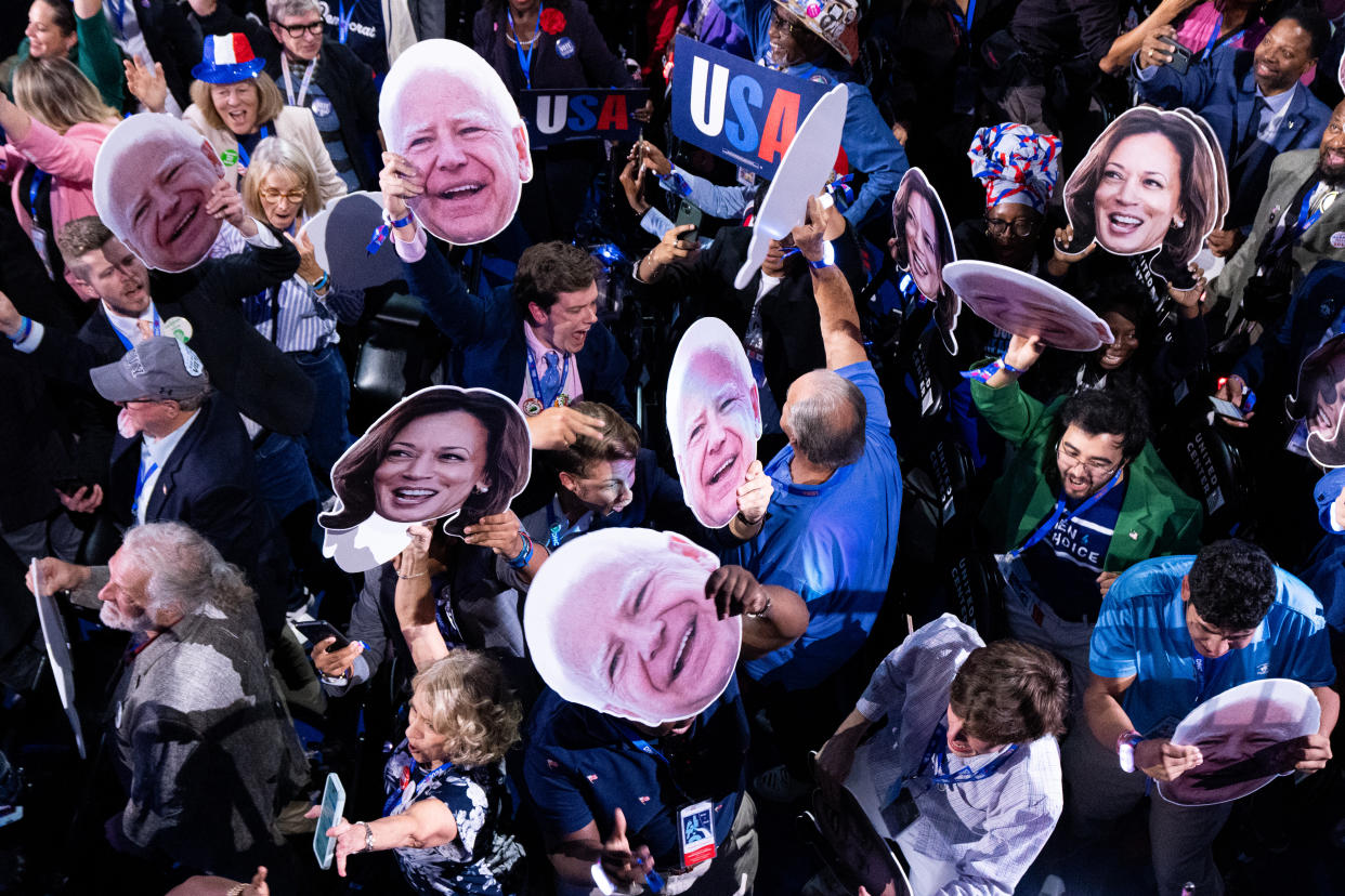 Delegates wave photos of Vice President Kamala Harris and Minnesota Gov. Tim Walz during the roll call vote on day two of the 2024 Democratic National Convention in Chicago on Tuesday. (Bill Clark/CQ-Roll Call, Inc via Getty Images)