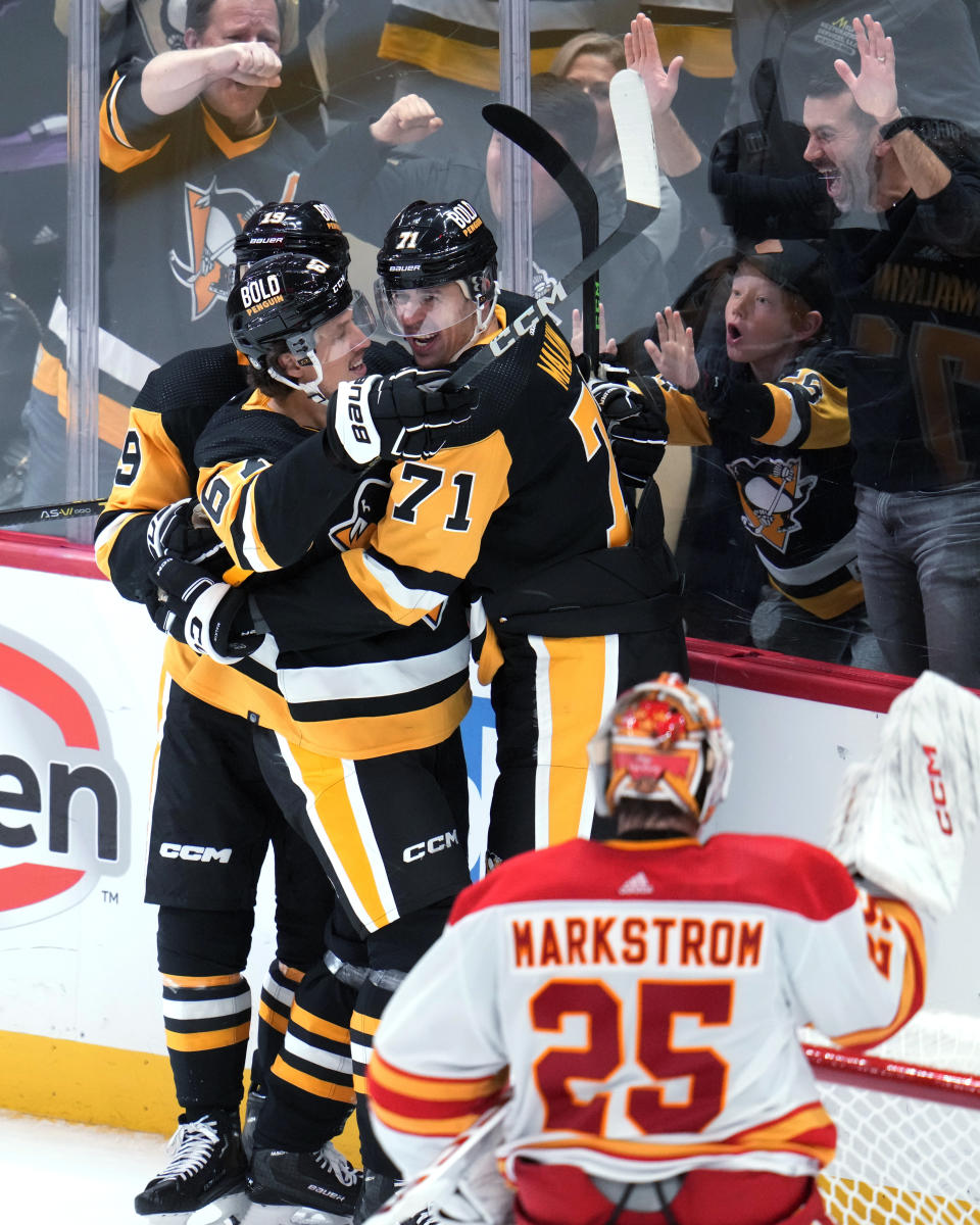 Pittsburgh Penguins' Evgeni Malkin (71) celebrates with Rickard Rakell (67) after scoring against Calgary Flames goaltender Jacob Markstrom (25) during the third period of an NHL hockey game in Pittsburgh, Saturday, Oct. 14, 2023. (AP Photo/Gene J. Puskar)