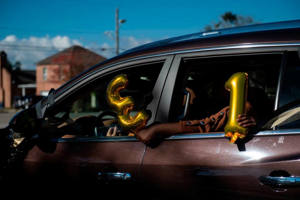 Parishioners hold balloons out of their car window for Pastor Seymour Venson Adolph, Jr.’s 31 years of leading Handsboro Baptist Church during a parade for his retirement in Gulfport on Saturday, Dec. 4, 2021.