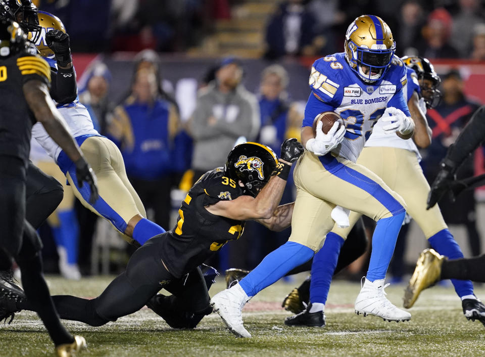 Andrew Harris #33 of the Winnipeg Blue Bombers attempts to break a tackle from Mike Daly of the Hamilton Tiger-Cats last year in the 107th Grey Cup Championship game. (Photo by John E. Sokolowski/Getty Images)