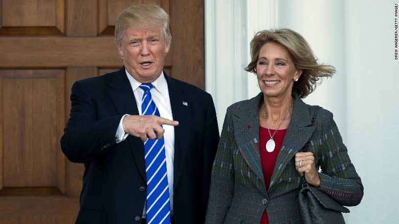 <p>Secretary of Education Betsy DeVos stands with President Trump during her visit at the White House. </p>