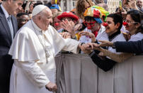 In the name of the Father, Son and the Holy Spirit...The head of the Catholic church greets the faithful, including some clows, in Vatican City.