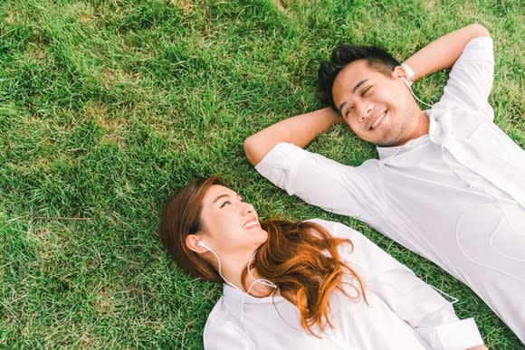 A Chinese couple laying on grass listening to music