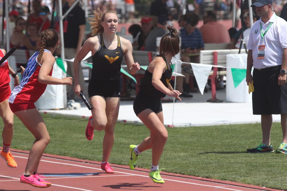 Colonel Crawford's Rylee Ritzhaupt passes the baton to Gabby Roston in the 4x400 relay.