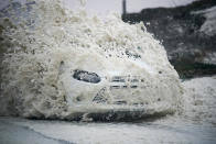 <p>A car drives through sea foam whipped up by the wind of Hurricane Ophelia at Trearddur Bay on Oct. 16, 2017 in Holyhead, Wales (Photo: Christopher Furlong/Getty Images) </p>