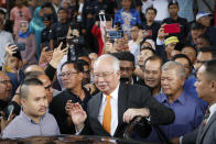 Former Malaysian Prime Minister Najib Razak, center, gets into his car outside Kuala Lumpur High Court in Kuala Lumpur, Monday, Nov. 11, 2019. A Malaysian judge on Monday ordered Najib to enter a defense at his first corruption trial linked to the multibillion-dollar looting at the 1MDB state investment fund that helped spur his shocking election ouster last year. (AP Photo/Vincent Thian)