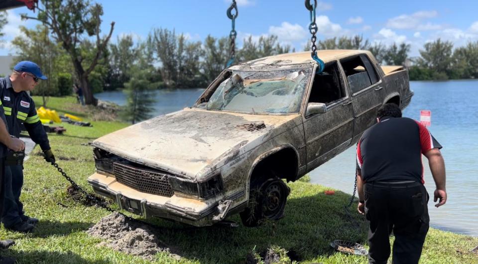 Miami-Dade Police Department divers assist with pulling one of approximately 30 cars out of a lake in Doral, Florida, on August 8, 2023.
