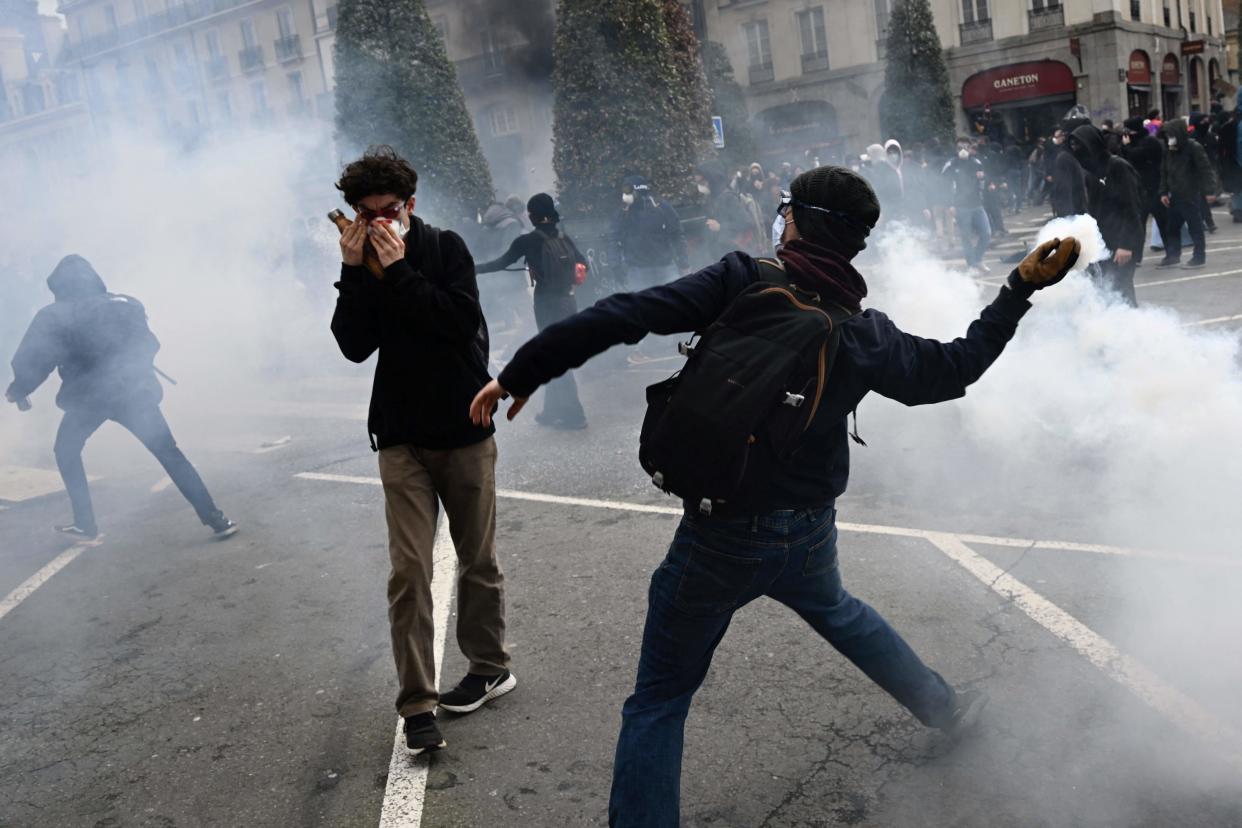 A protester throws a tear gas grenade back at riot police in Rennes, western France (AFP/Getty)