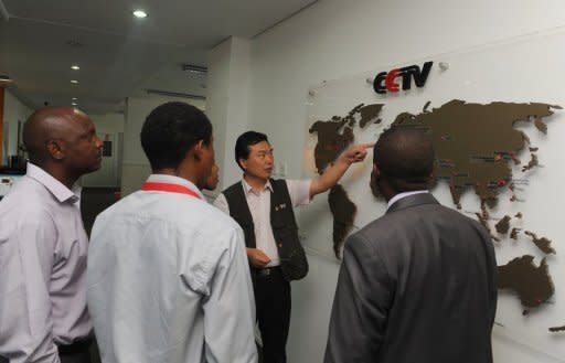 Pang Xinhua (2nd R), CCTV's managing editor who runs a network of correspondents in a dozen African countries, points to a map to show local correspondents how the organisation has expanded in different parts of Africa