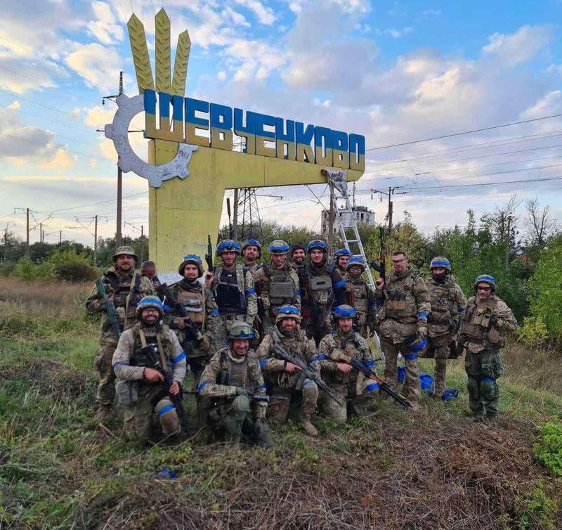 Ukrainian service members pose for in the recently liberated settlement of Vasylenkove in Kharkiv region