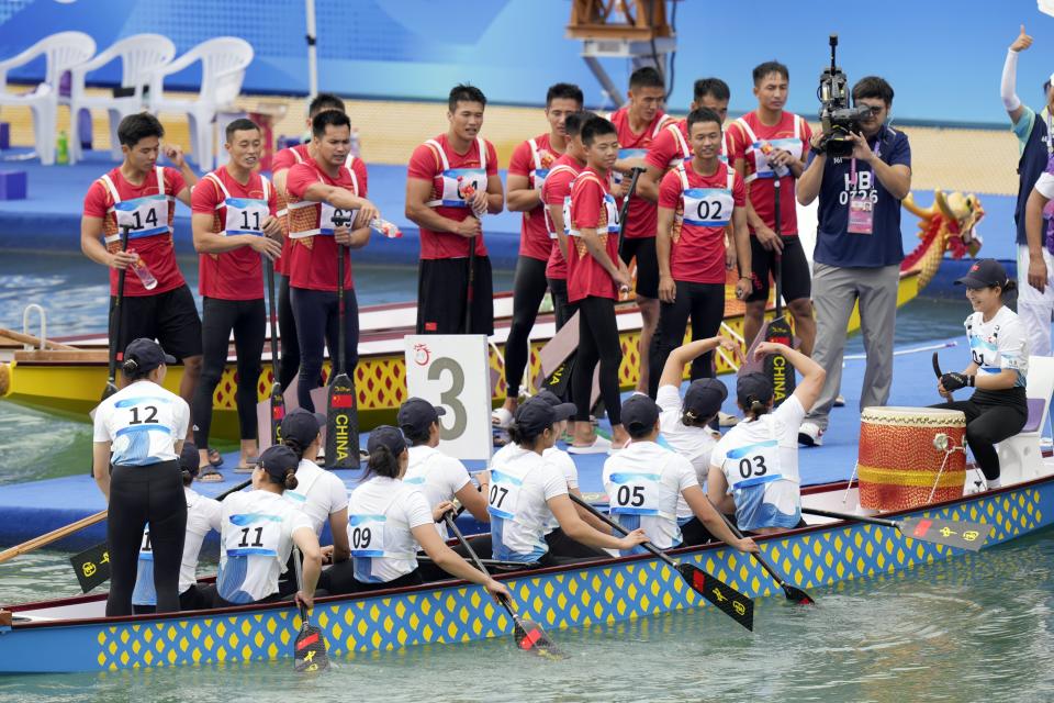 China's men's and women's dragon boat teams greet each other after both team won the golds for the men' and women's Dragon Boat 500m classes at the Wenzhou Dragon Boat Center during the 19th Asian Games in Wenzhou, China, Wenzhou, Thursday, Oct. 5, 2023. (AP Photo/Eugene Hoshiko)