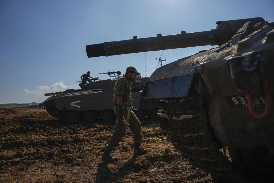 Israeli soldiers work on their tank in a staging area at the Israeli-Gaza border in southern Israel, Thursday, Jan. 4, 2024. (AP Photo/Ariel Schalit)