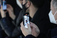 Audience members record on their cell phones models wearing creations for the Dior Spring-Summer 2022 Haute Couture fashion collection collection, in Paris, Monday, Jan. 24, 2022. (AP Photo/Michel Euler)