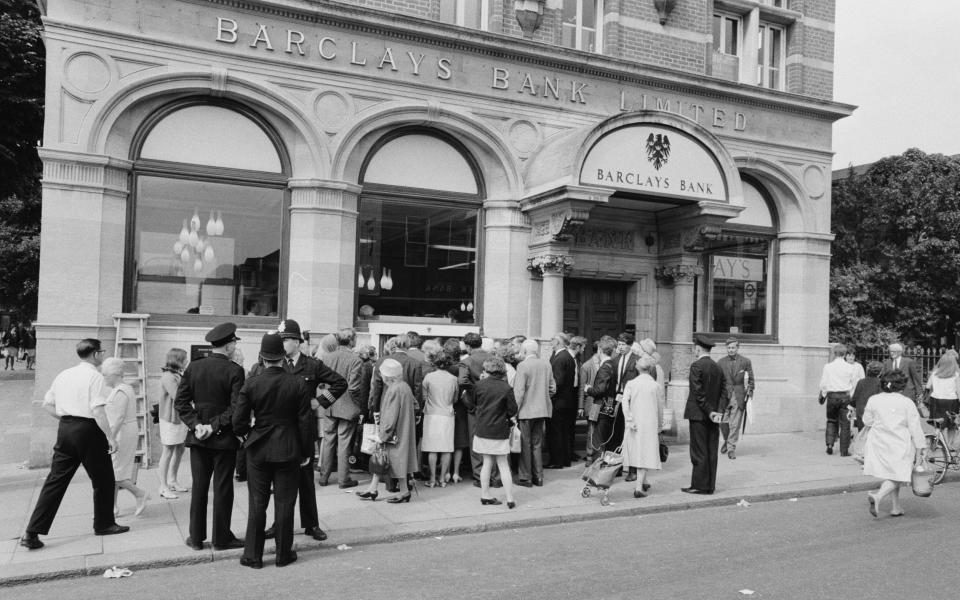 Crowds gather to catch a glimpse of the cash machine in action following its grand unveiling - Mirrorpix