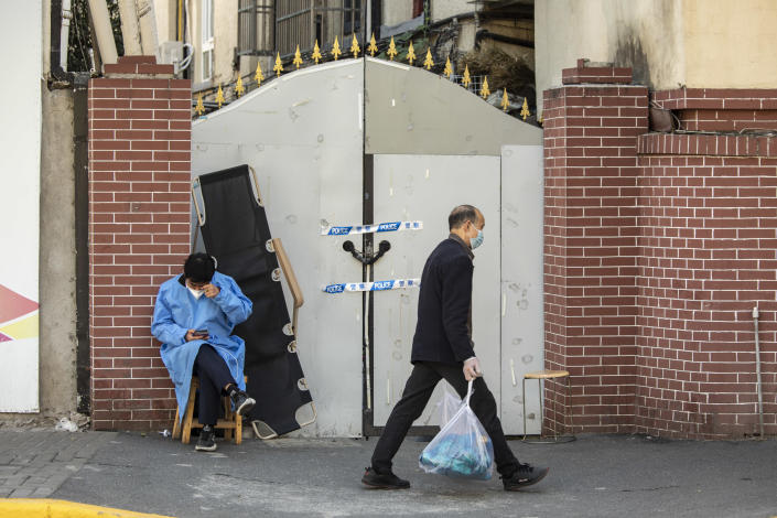 A worker in protective gear guards an entrance to a neighborhood placed under lockdown due to COVID-19 in Shanghai, China, November 7, 2022. / Credit: Qilai Shen/Bloomberg/Getty