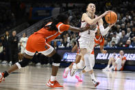UConn guard Paige Bueckers, right, looks to pass while guarded by Syracuse forward Alyssa Latham, left, in the first half of a second-round college basketball game in the NCAA Tournament, Monday, March 25, 2024, in Storrs, Conn. (AP Photo/Jessica Hill)