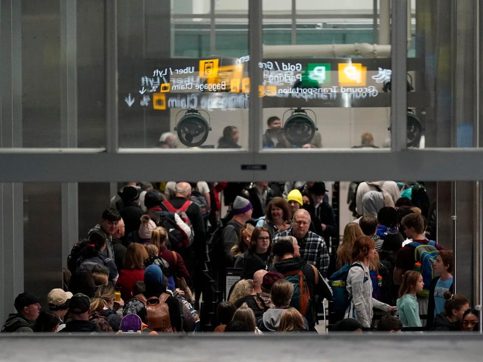 Travelers wait in line to go through security in Terminal 1 at Minneapolis St. Paul Airport, Wednesday, Dec. 21, 2022, in Minneapolis.