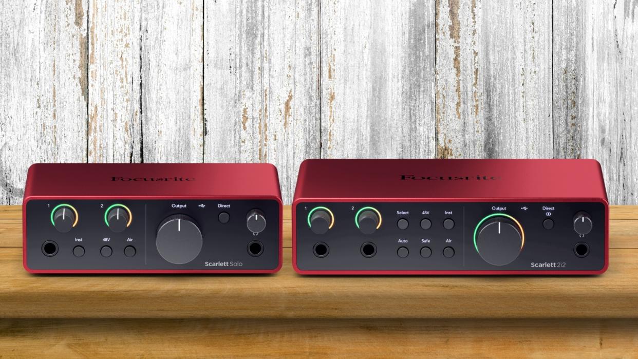  Two Focusrite Scarlett audio interfaces side by side on a wooden desk. 