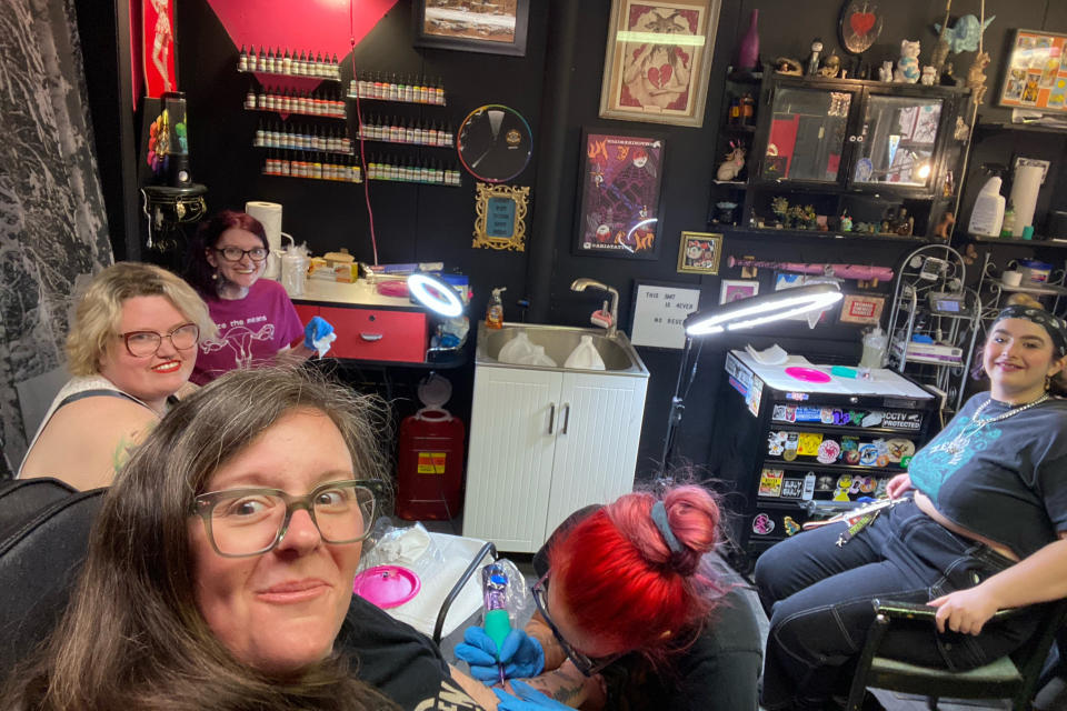 In this photo provided by Alison Dreith, she, bottom left, and a group of friends who all work in abortion support and advocacy have their photo made while getting tattoos on Thursday, April 7, 2022, in Richmond, Ind. Dreith's tattoo was a drawing of abortion pills. (Alison Dreith via AP)