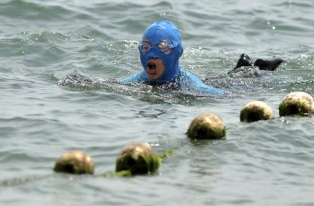A woman wearing a face-kini mask swims in the ocean in Qingdao, Shandong province, China, June 3, 2015. REUTERS/Stringer