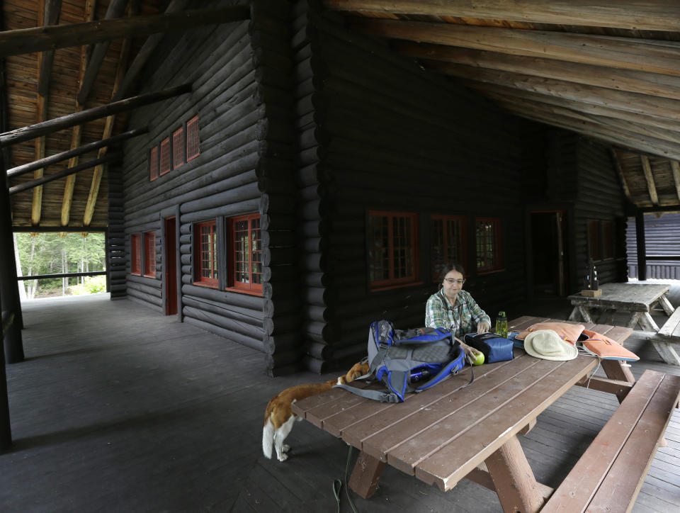 In this Tuesday, July 30, 2013 photo, Cynthia Taylor, of Watertown, Mass., has lunch on the porch at Camp Santanoni, an Adirondack great camp that is being restored, in Newcomb, N.Y. Santanoni was one of the earliest great camps built by wealthy families with names like Rockefeller and Vanderbilt beginning in the late 19th century. Managed by state environmental officials, it is the only remaining great camp that is publicly owned. (AP Photo/Mike Groll)